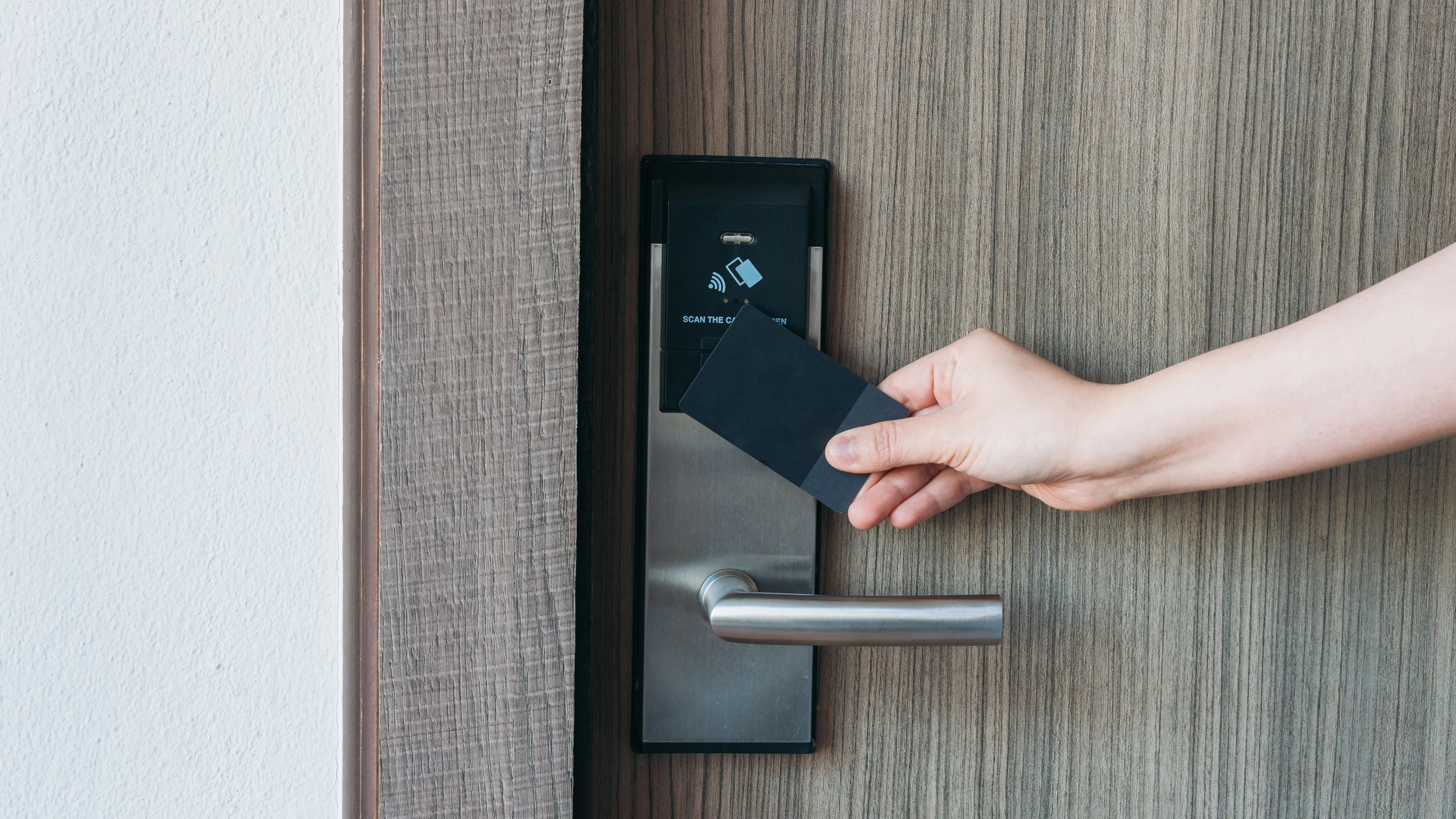 An NFC-enabled card is held up to an NFC door lock to open the door.